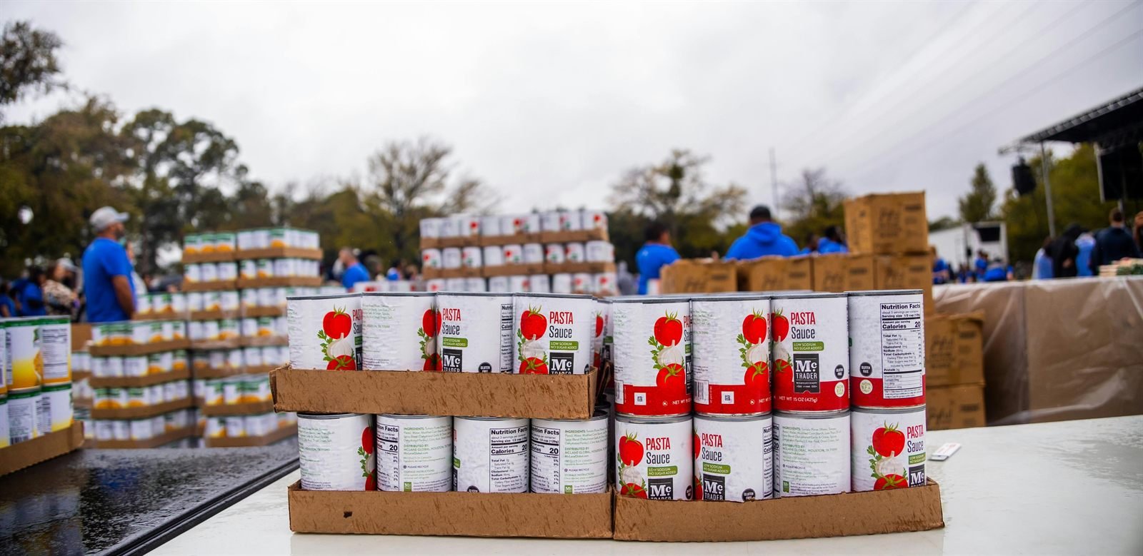 Volunteers organizing canned goods at a community food drive